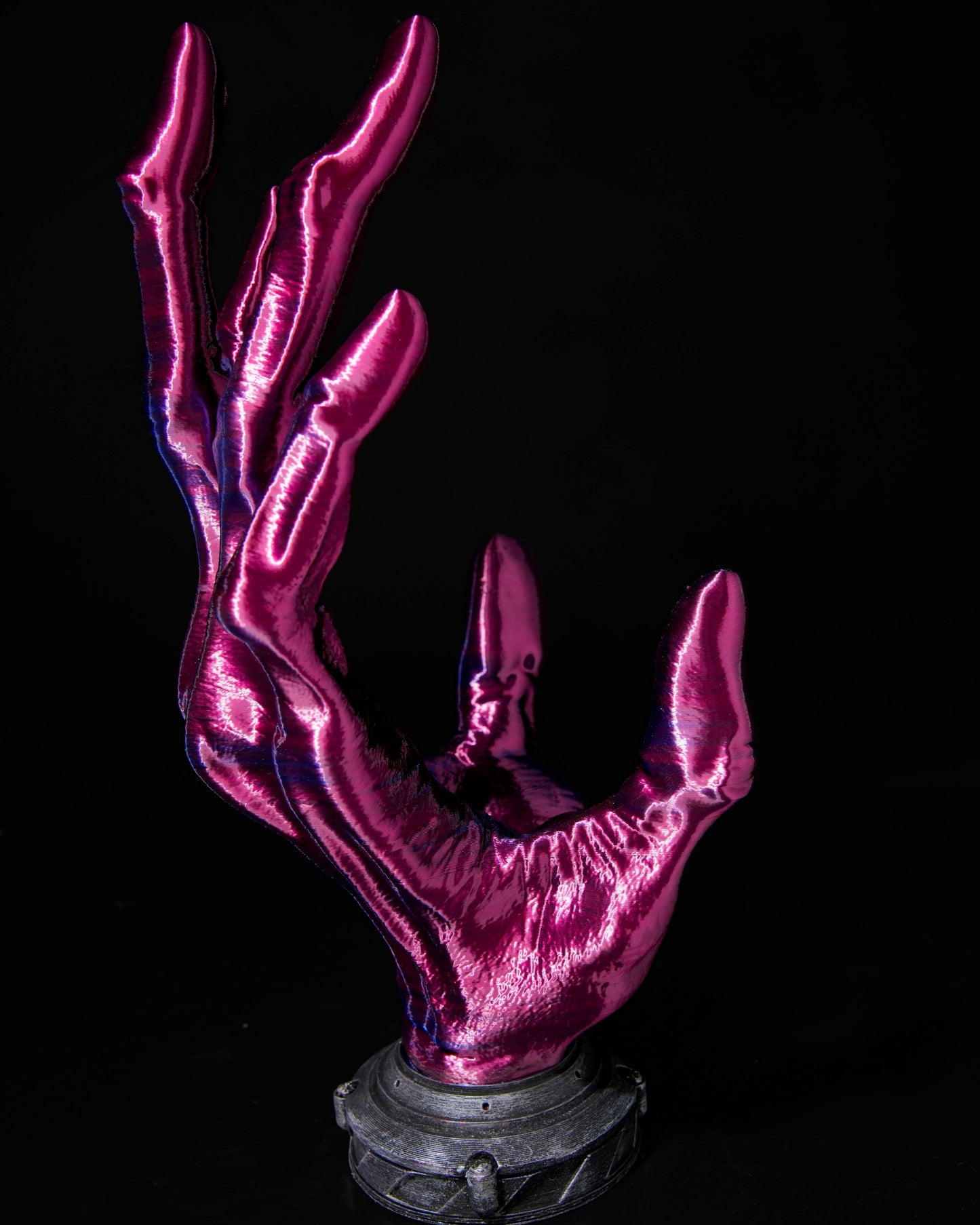 purple glowing hand sculpture on a black background
