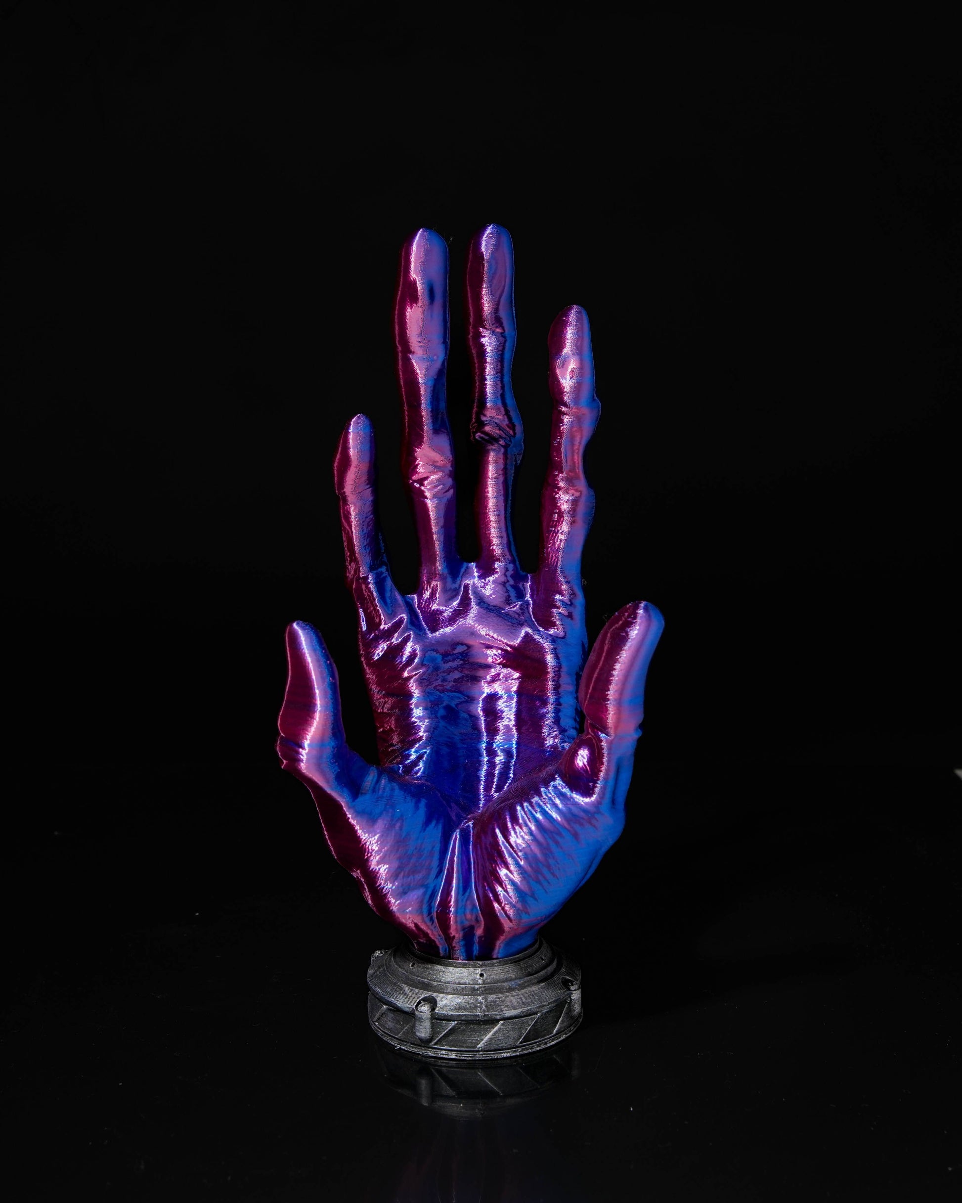 Glowing purple and blue hand sculpture on a black background